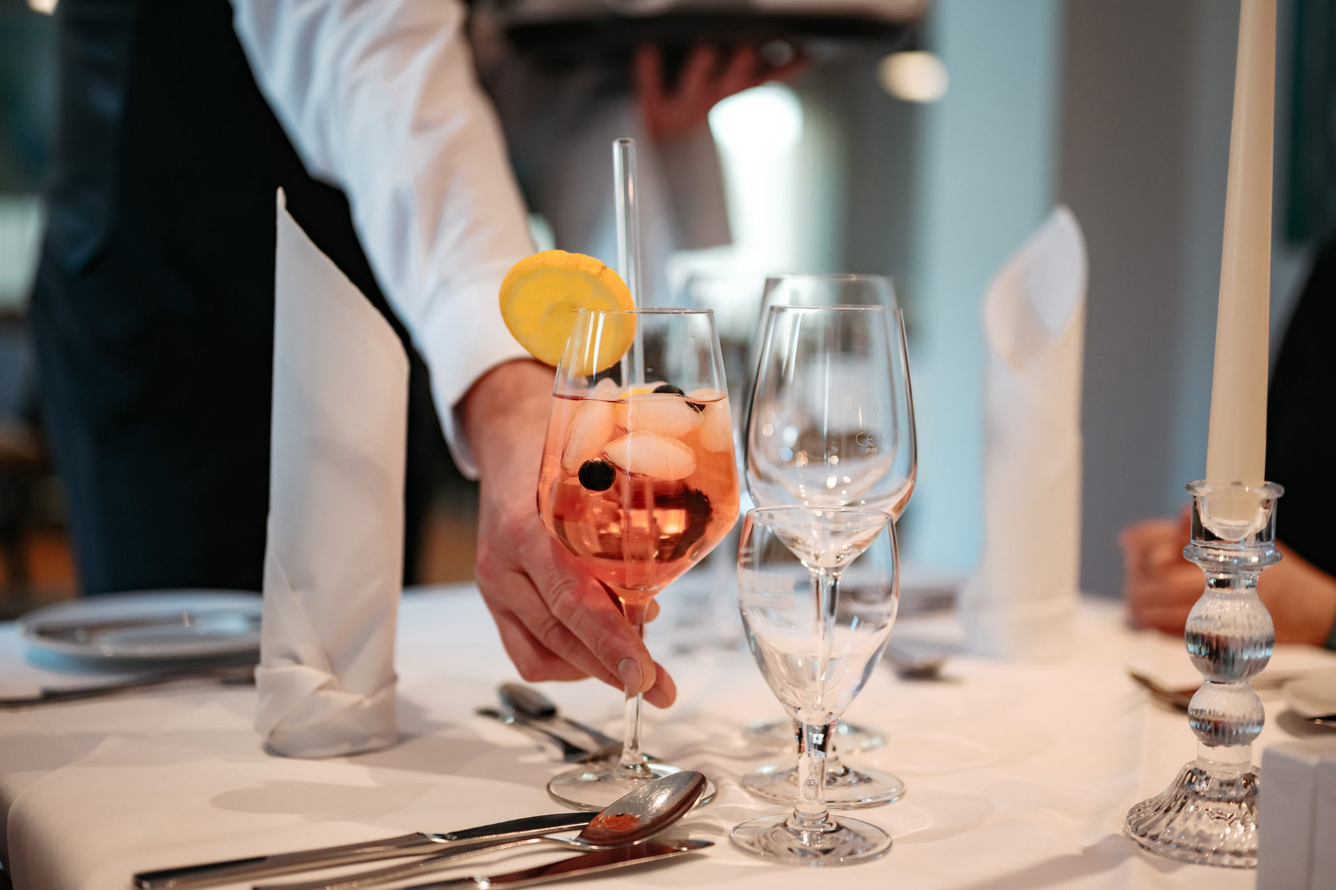Servicekraft serviert ein Glas Aperol Spriz