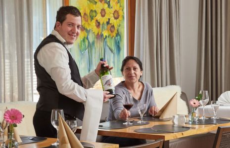 Eine Servicekraft mit Behinderung bedient einen Gast