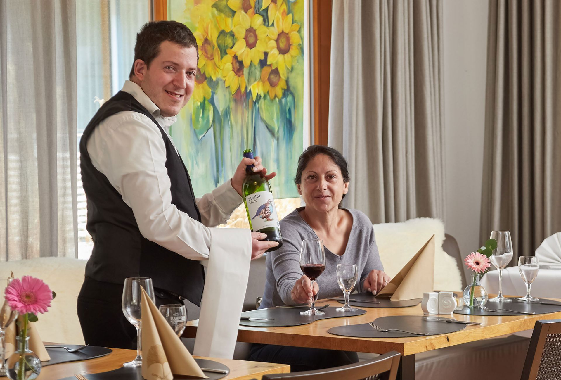 Eine Servicekraft mit Behinderung bedient einen Gast