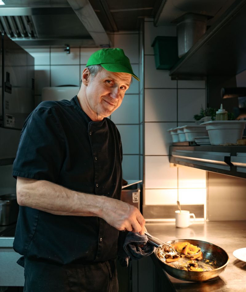 Küchenmitarbeiter mit Pfanne in der Hand