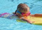 Kind mit Schwimmbrett im Wasser