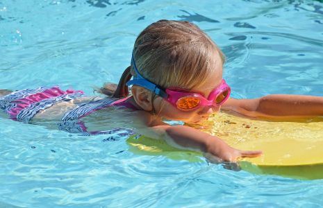 Kind mit Schwimmbrett im Wasser