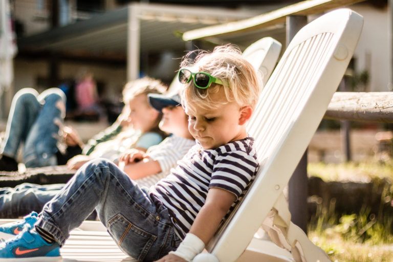 Kleinkinder auf einem Liegestuhl in der Sonne